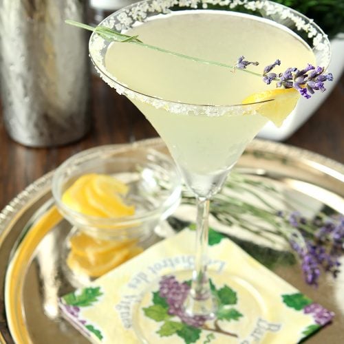 Lavender Lemonade Martini on a Serving Tray Garnished with Lemon and Sprig of Lavender.