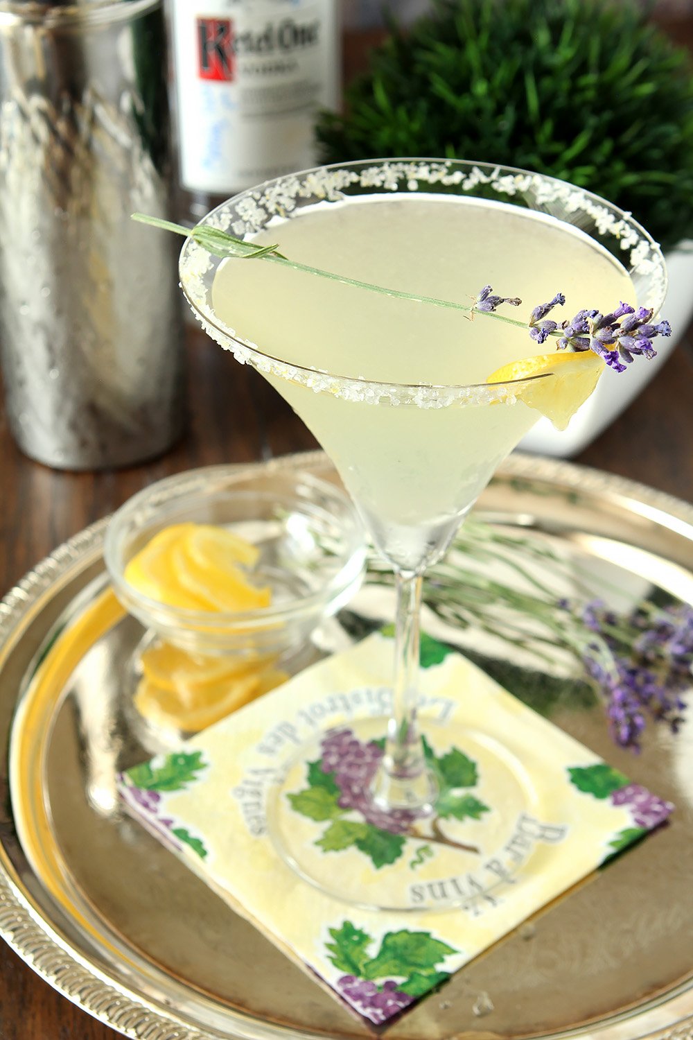 Lavender Lemonade Martini on a Serving Tray Garnished with Lemon and Sprig of Lavender.