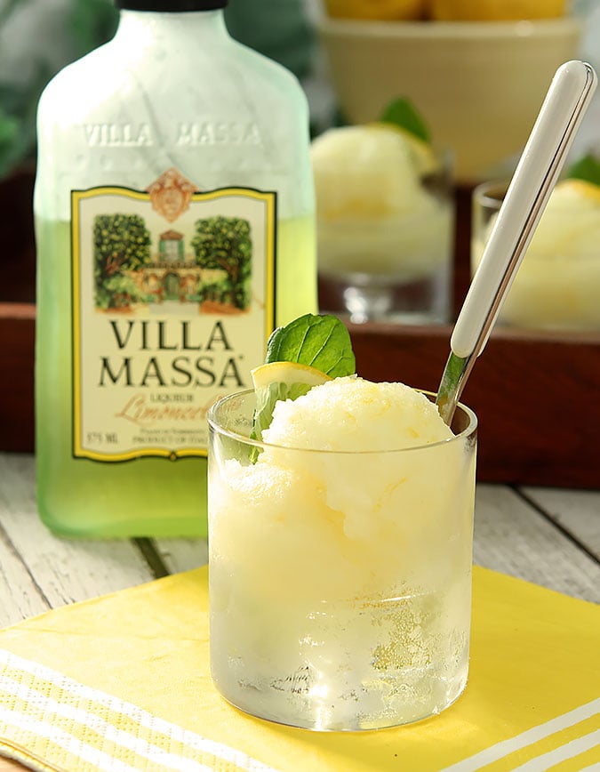 Limoncello Sorbet in a clear, short glass sitting in front of a bottle of Villa Massa Limoncello.