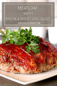 Meatloaf with Bacon and Sausage and a Sweet Chili Glaze on a Serving Plate and Garnished with a Sprig of Parsley