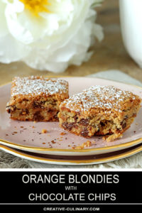 Chocolate Chip Blondies with Orange Zest on Pink Plate and Dusted with Powdered Sugar