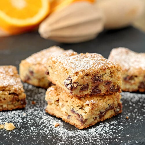 Chocolate Chip Blondies with Orange Zest Stacked and Dusted with Powdered Sugar