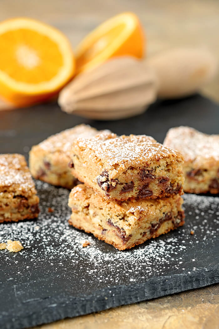 Chocolate Chip Blondies with Orange Zest Stacked and Dusted with Powdered Sugar