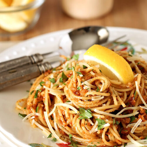 Plate of Pasta with Sun-Dried Tomato and Roasted Almond Pesto with a Lemon Garnish