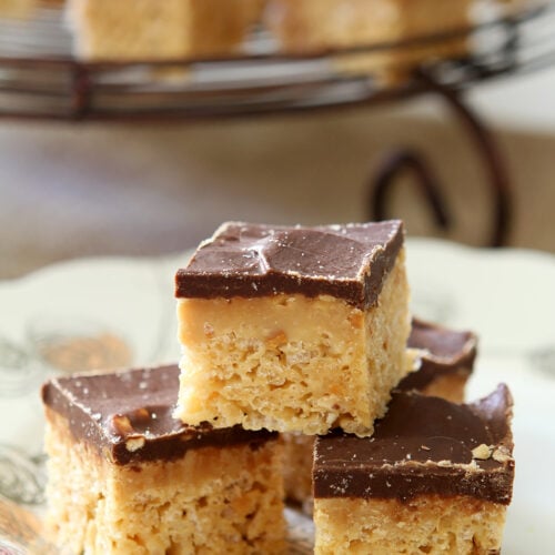 Peanut Butter Cup Rice Krispies stacked on a white plate with a turquoise napkin.