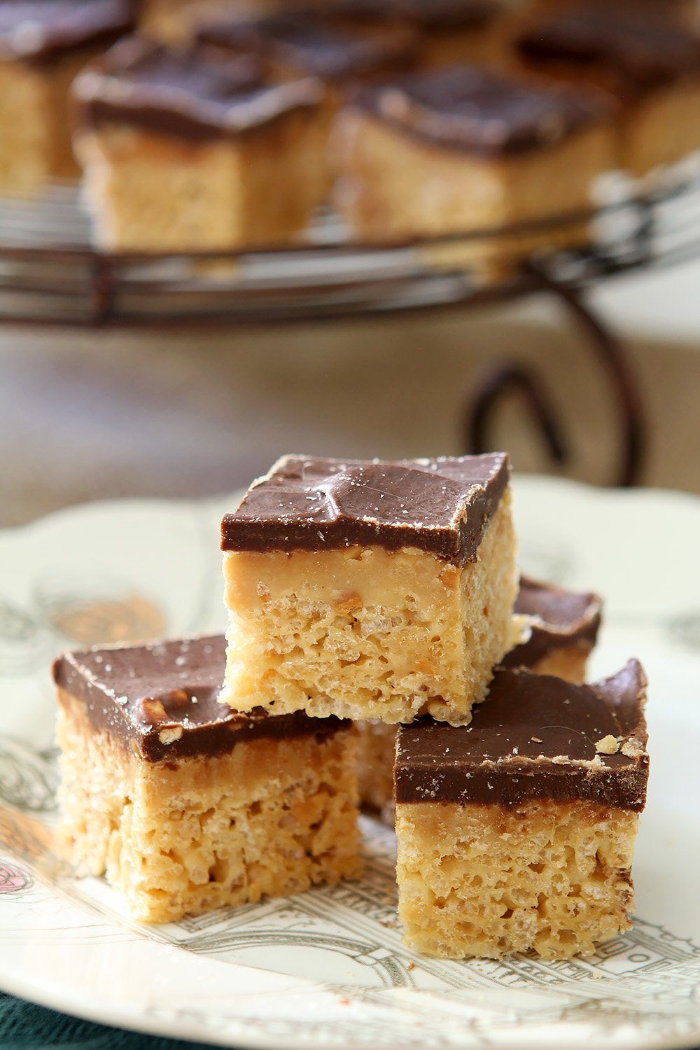 Peanut Butter Cup Rice Krispies stacked on a white plate with a turquoise napkin.