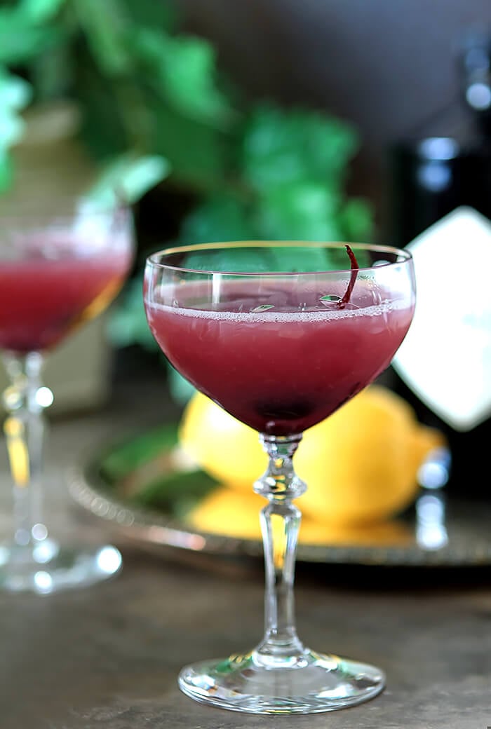 A coupe glass filled with gin, lemon juice, and grenadine, the Pink Lady Cocktail