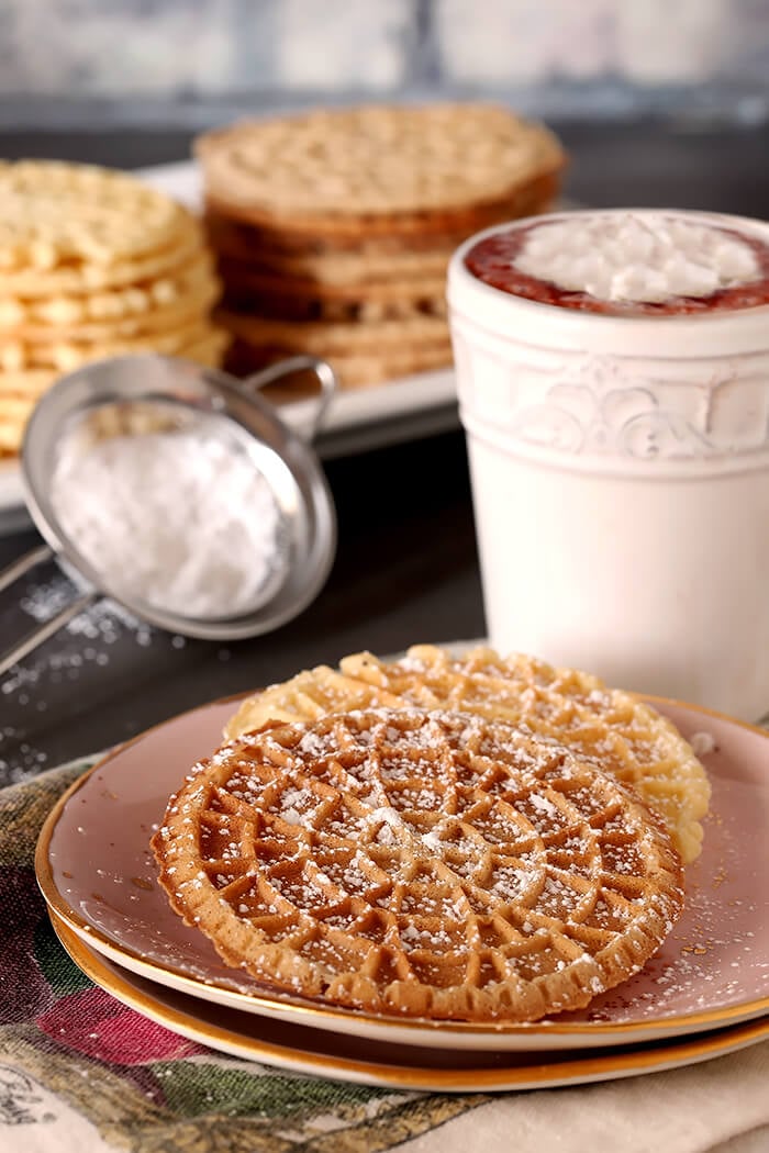 Pizzelles - Italian Waffle Cookies Sprinkled with Powdered Sugar