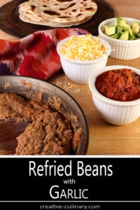 Skillet of Refried Beans with Garlic and Bowls of Condiments