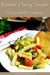 Roasted Cherry Tomato Pasta with Capers Served on a White Plate with Garlic Toast