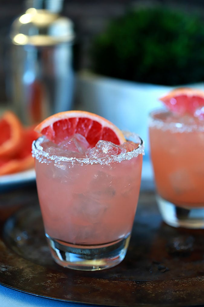 A cocktail made with vodka and grapefruit juice sits on a tray.