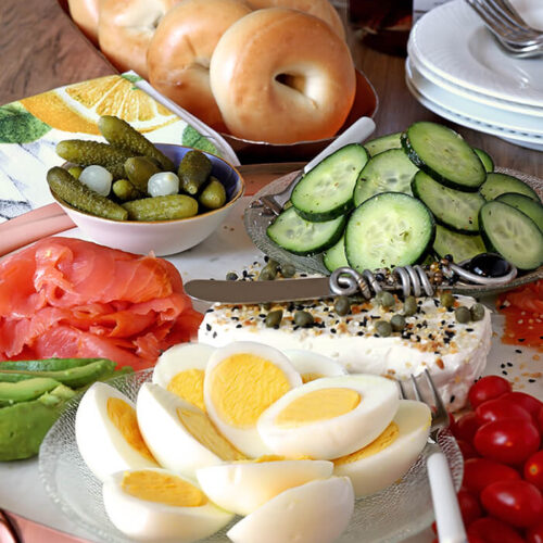 Marble Serving Board with Salmon, Avocado, Hard Boiled Eggs, Cream Cheese, Cucumbers, Red Onion, and Tomatoes Accented with Everything Spice Mix