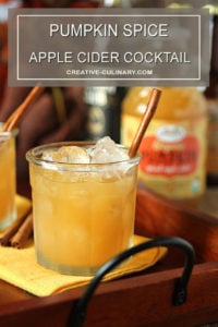 Pumpkin Spiced Apple Cider Cocktail in a Lowball Glass on a Wood and Wrought Iron Tray