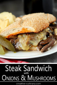 Steak and Cheese Sandwich with Caramelized Onions and Mushrooms Served on a White Plate with Dill Pickles and Chips