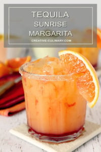 Tequila Sunrise Margarita with a Sugar Rim Garnish and Orange Section.