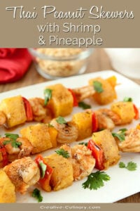 Thai Peanut Skewers with Shrimp and Pineapple on a White Serving Plate