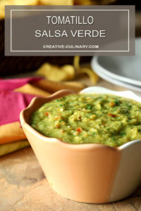 Tomatillo Salsa Verde (Green Salsa) on Table with Chips and Plates