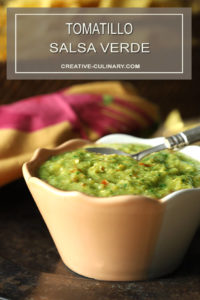 Tomatillo Salsa Verde (Green Salsa) on Table with Chips and Plates