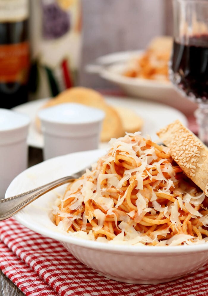 Tomato Sauce with Butter and Onion Served in a White Bowl and Parmesan Cheese and Italian Bread