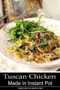 Mushrooms, Sun-Dried Tomatoes, and Spinach are all in this Instant Pot Tuscan Chicken Served on a White Plate